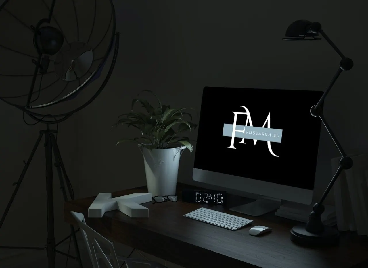 Desk with a computer showing the FM Search logo